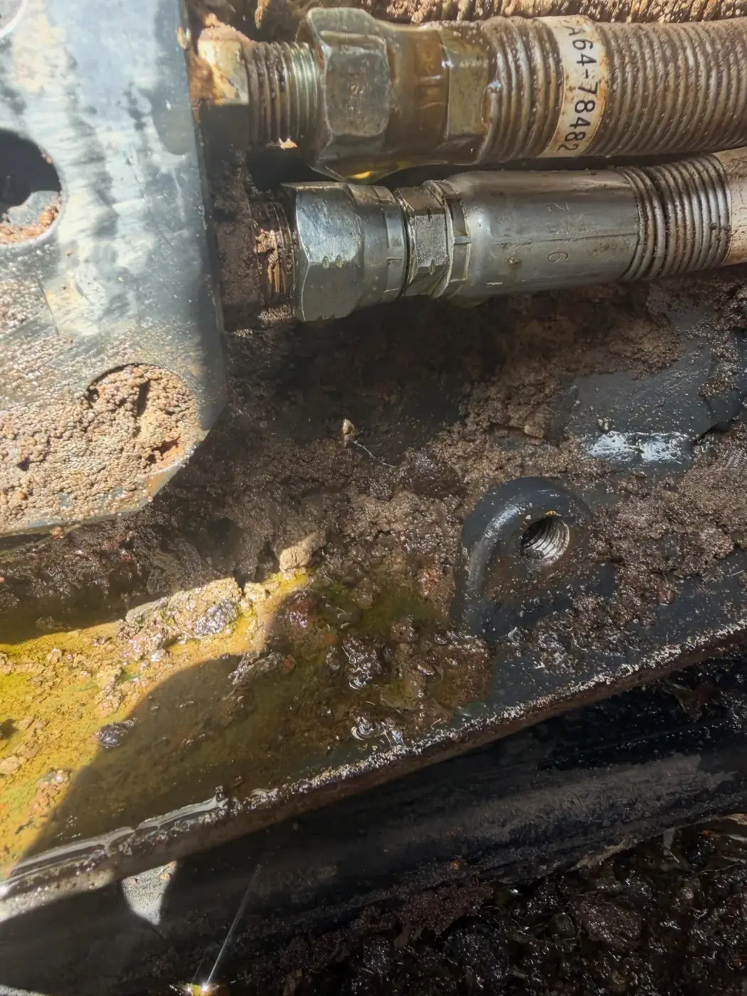 Hydraulic oil weeping from a hose fitting, found on site